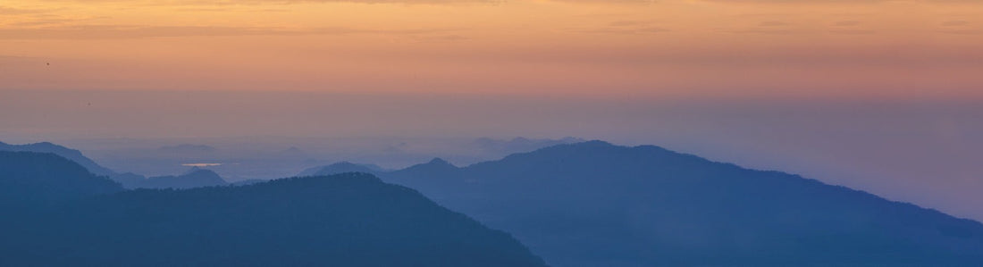 An orange and purple sunset with mountains