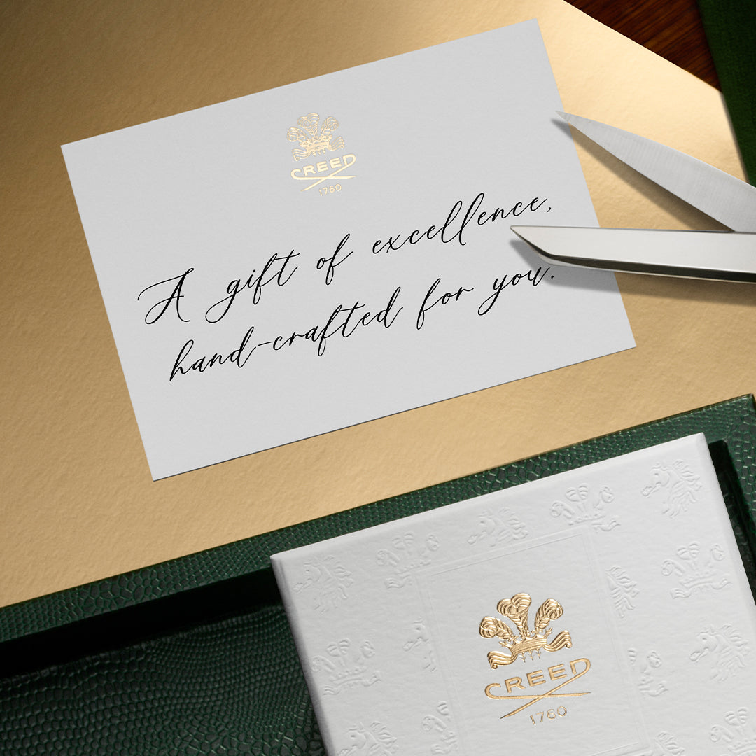 Crew branded gift card with a card and scissors on a wooden surface
