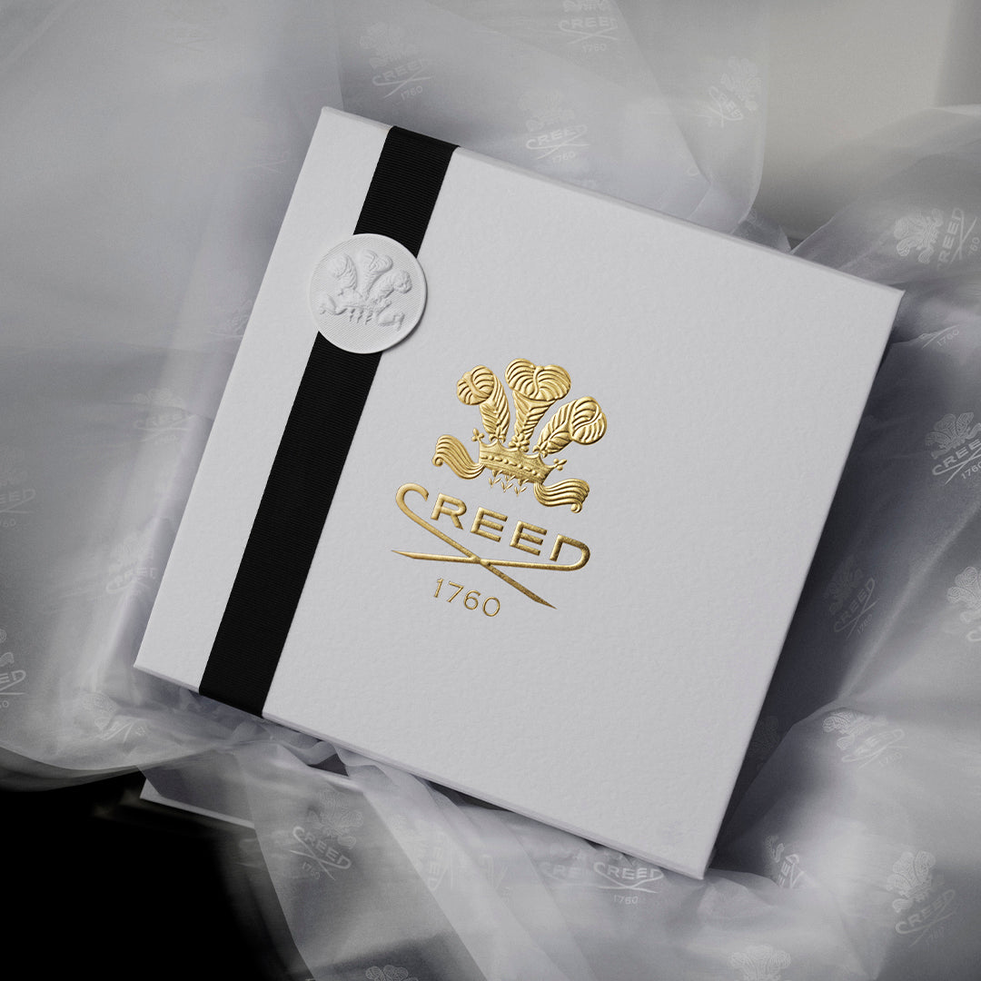Elegant Creed gift box with black ribbon and embossed logo.