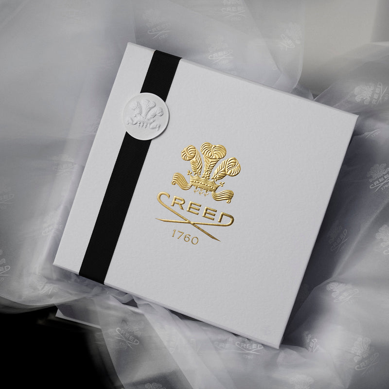 Elegant Creed gift box with black ribbon and embossed logo.