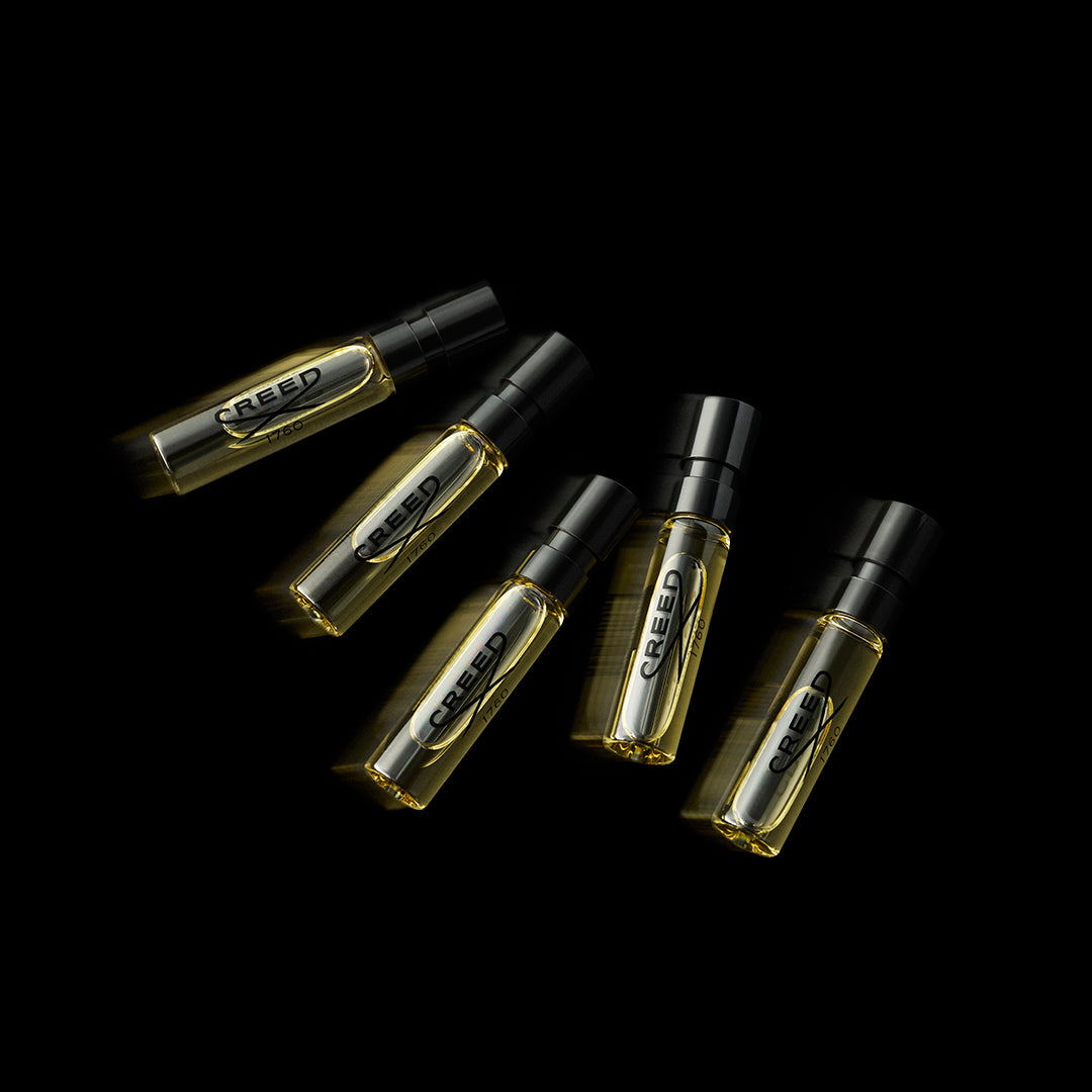 Creed fragrance samples in elegant black display with golden details.