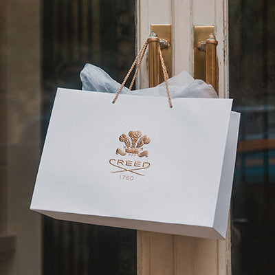 A creed shopping bag hanging on a door