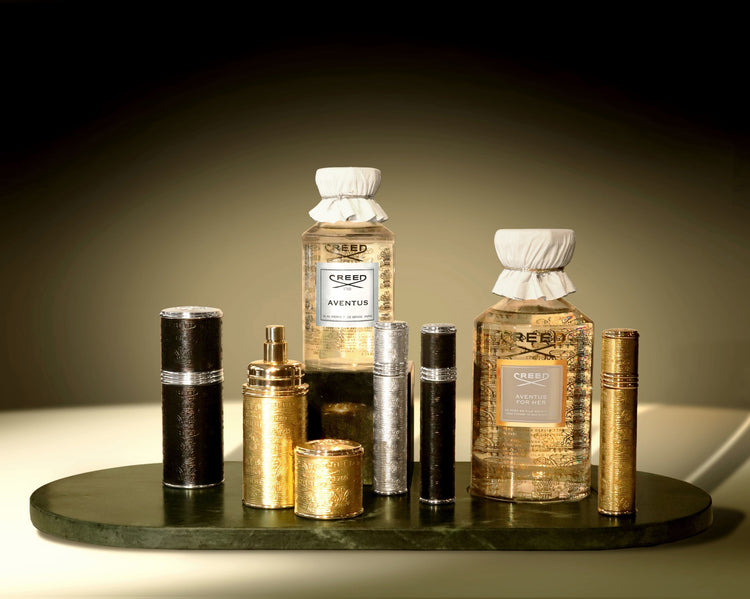 Collection of Creed perfume bottles on a dark surface with a gradient background Collection of Creed perfume bottles on a dark surface with a gradient background