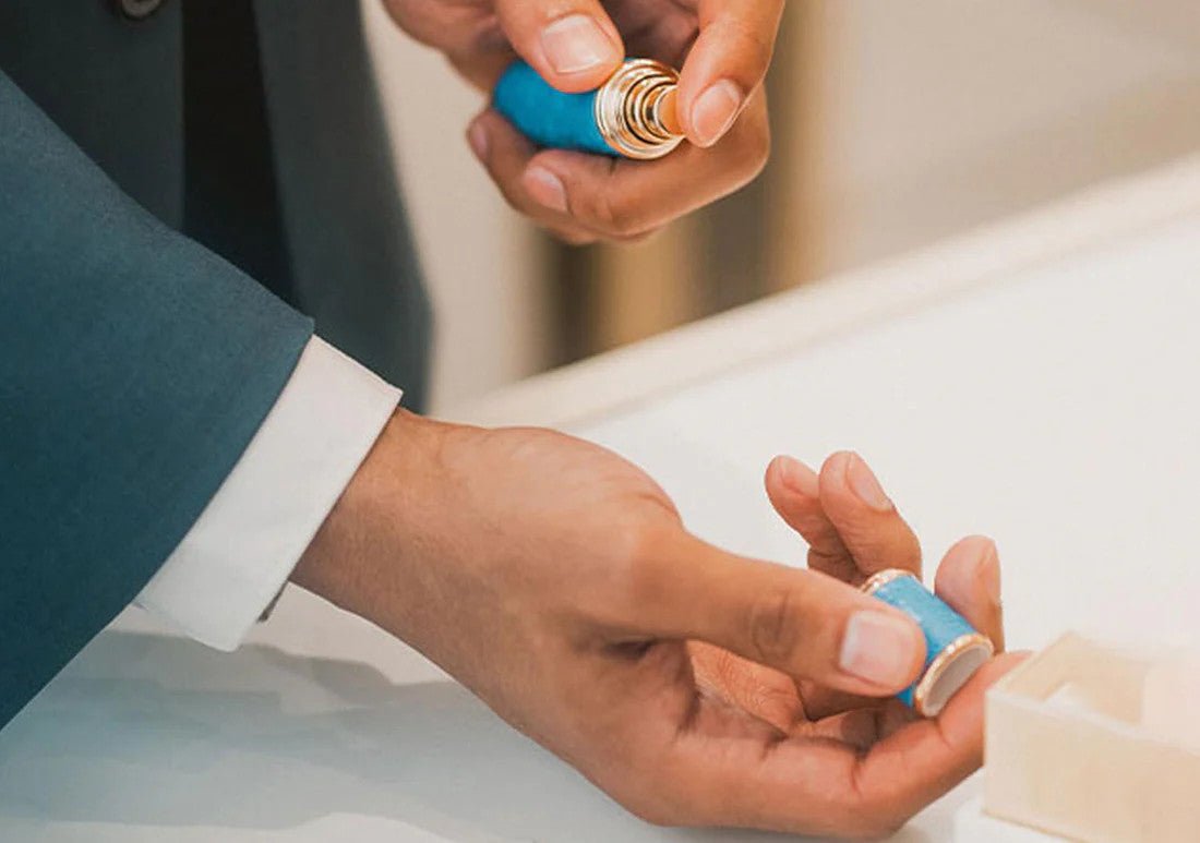 Someone is spraying a blue atomizer onto his hand