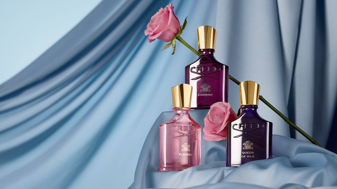 Carmina, Eladaria, and Queen of Silk 75ml bottles with a single rose and blue silk sheet