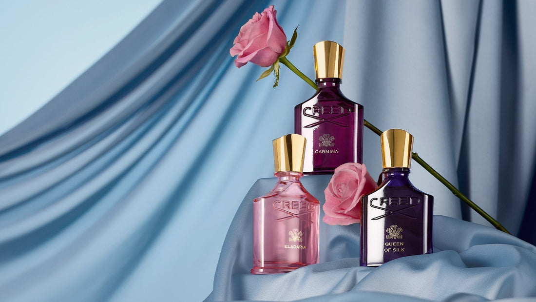 Carmina, Eladaria, and Queen of Silk 75ml bottles with a single rose and blue silk sheet