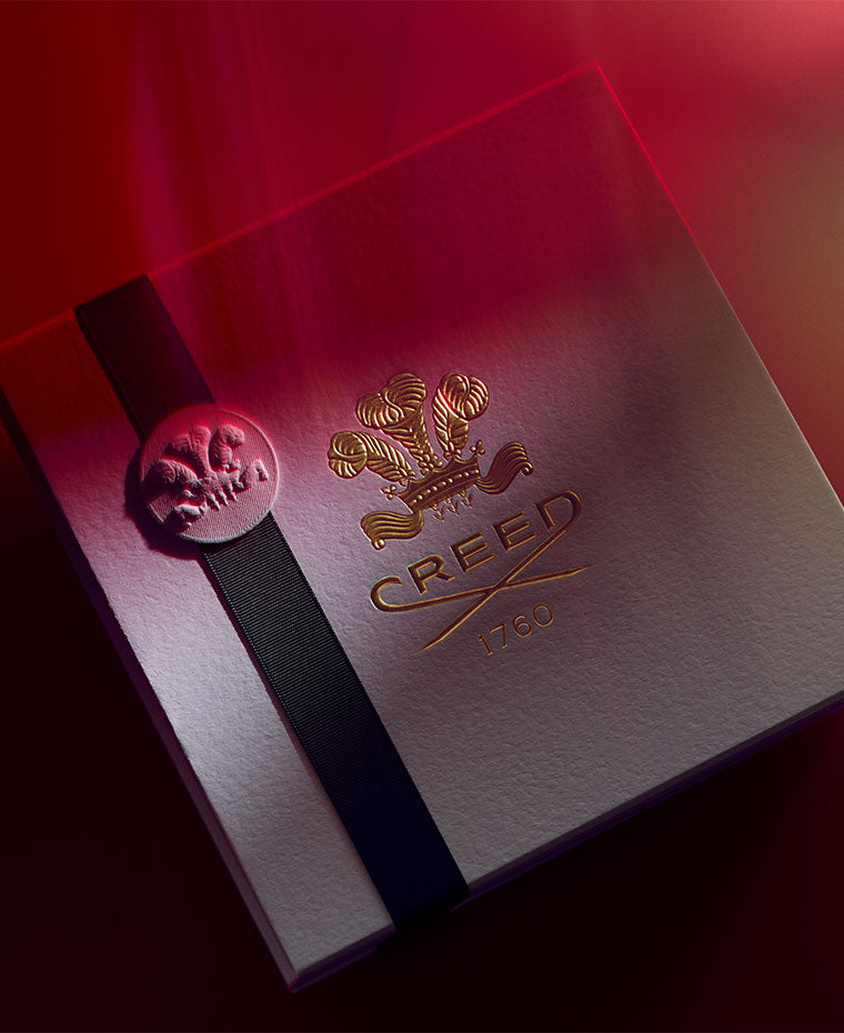a creed gift box with a black ribbon and red filter