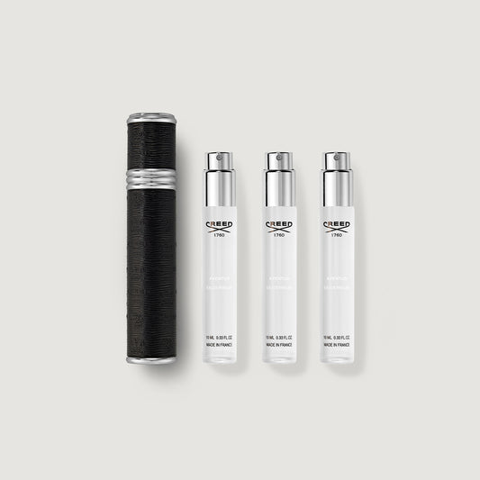 Set of Creed perfume bottles on a light gray background