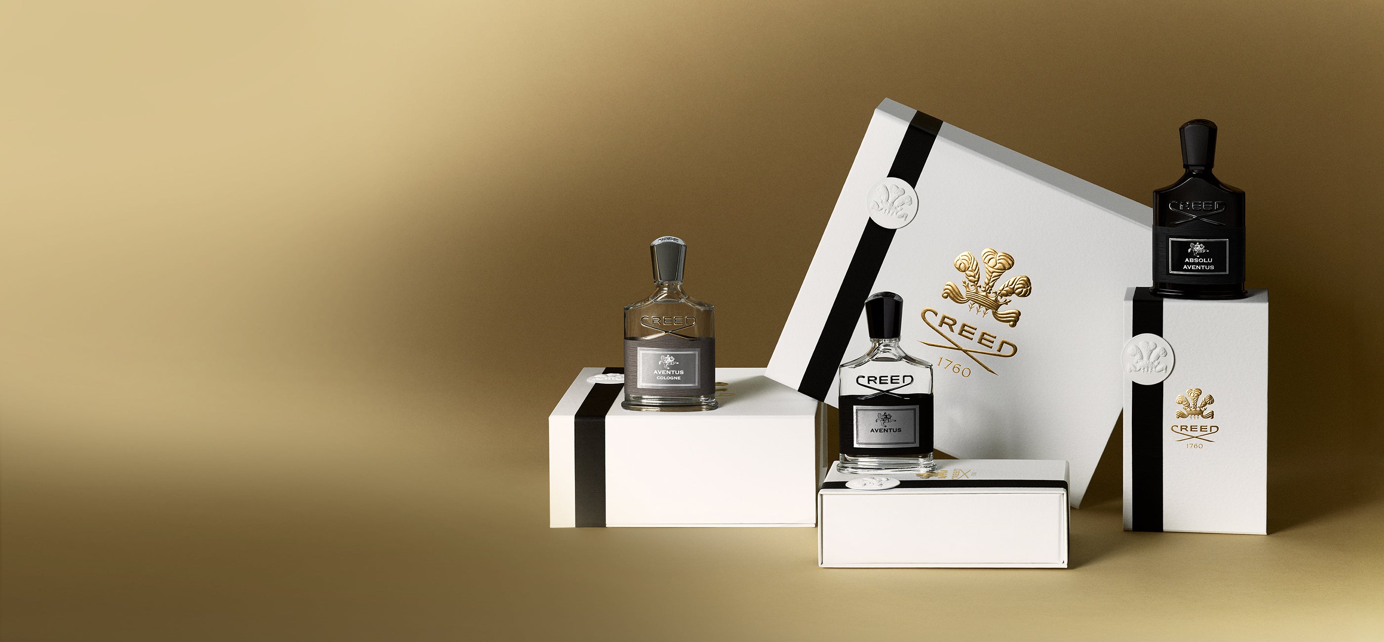 Creed perfume bottles and packaging on a gold background