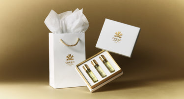 Creed perfume set with white packaging on a gold background