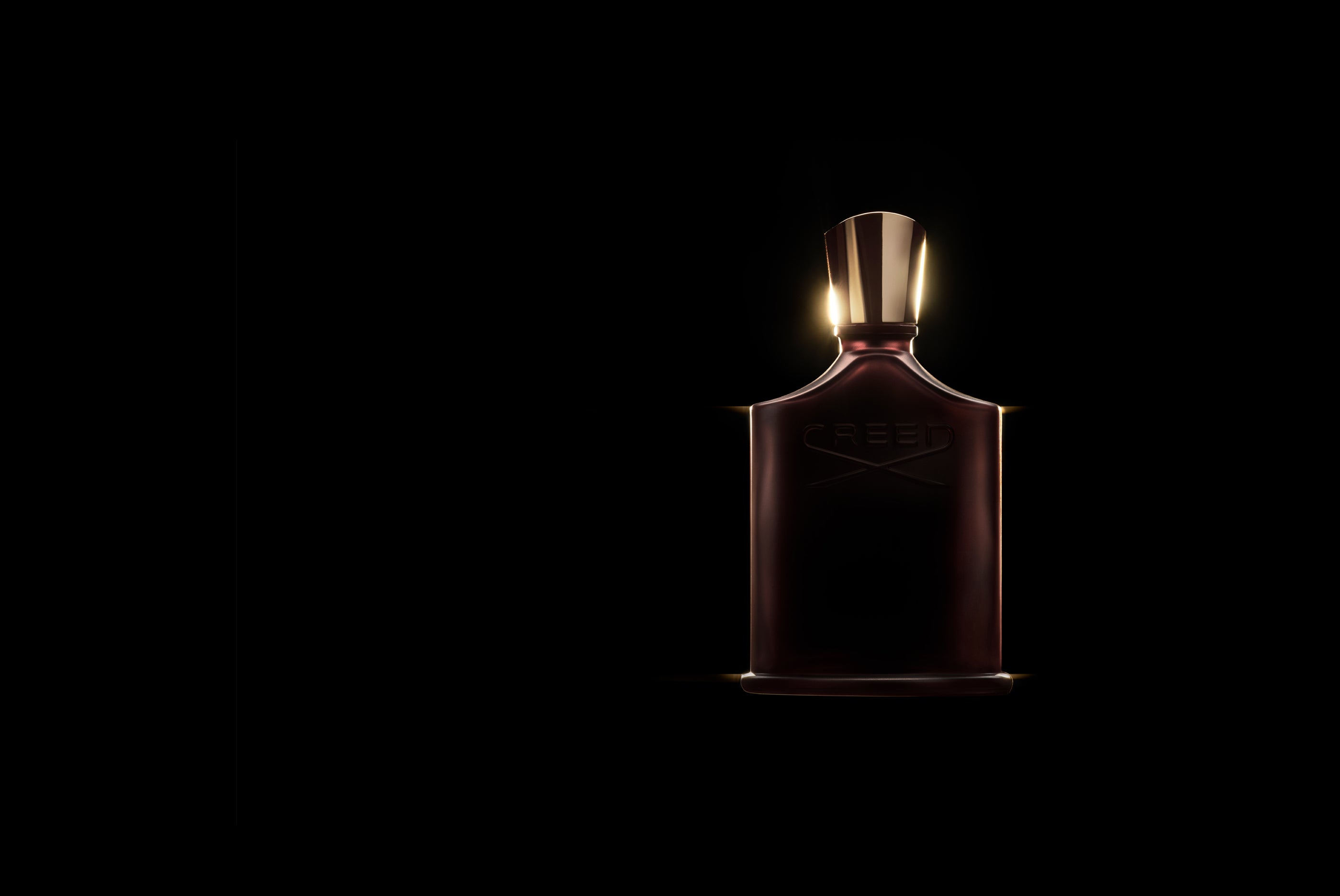 Creed Oud Zarian perfume bottle with gold cap and a dark and dramatic background