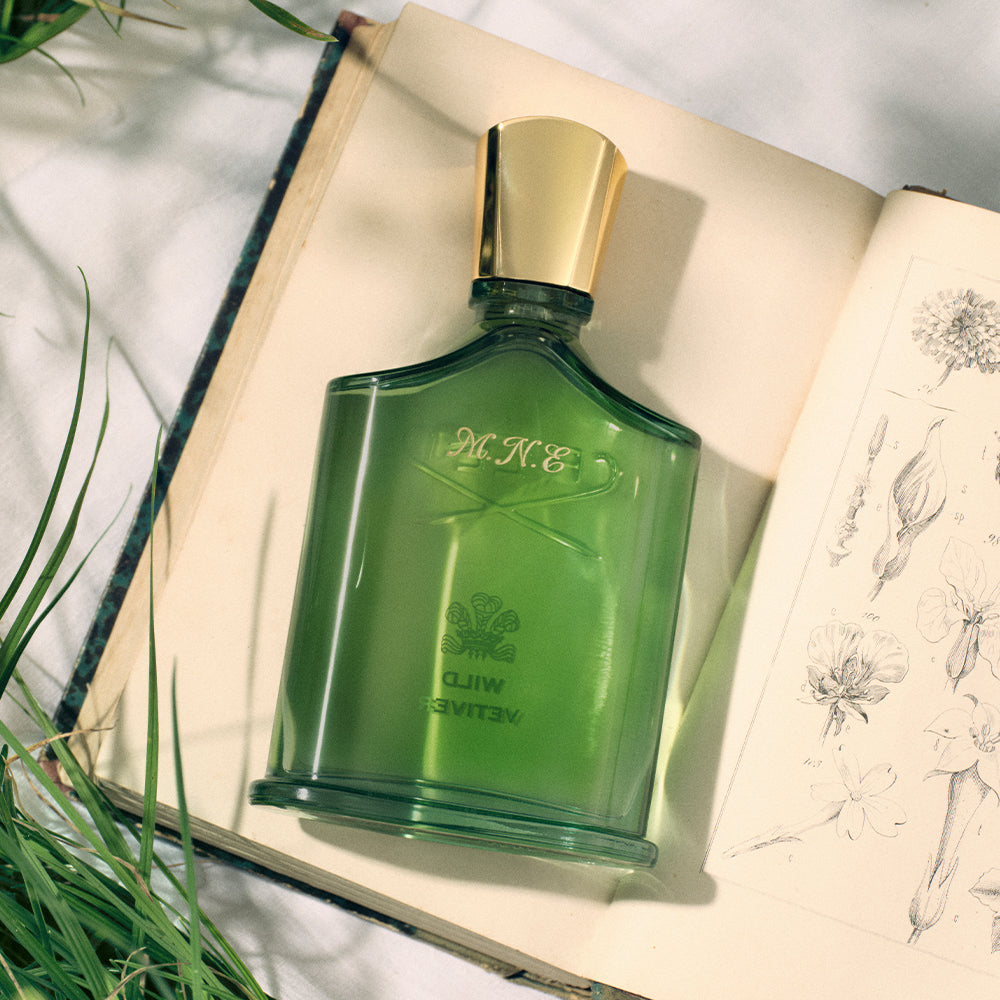 Green perfume bottle with gold cap on an open book