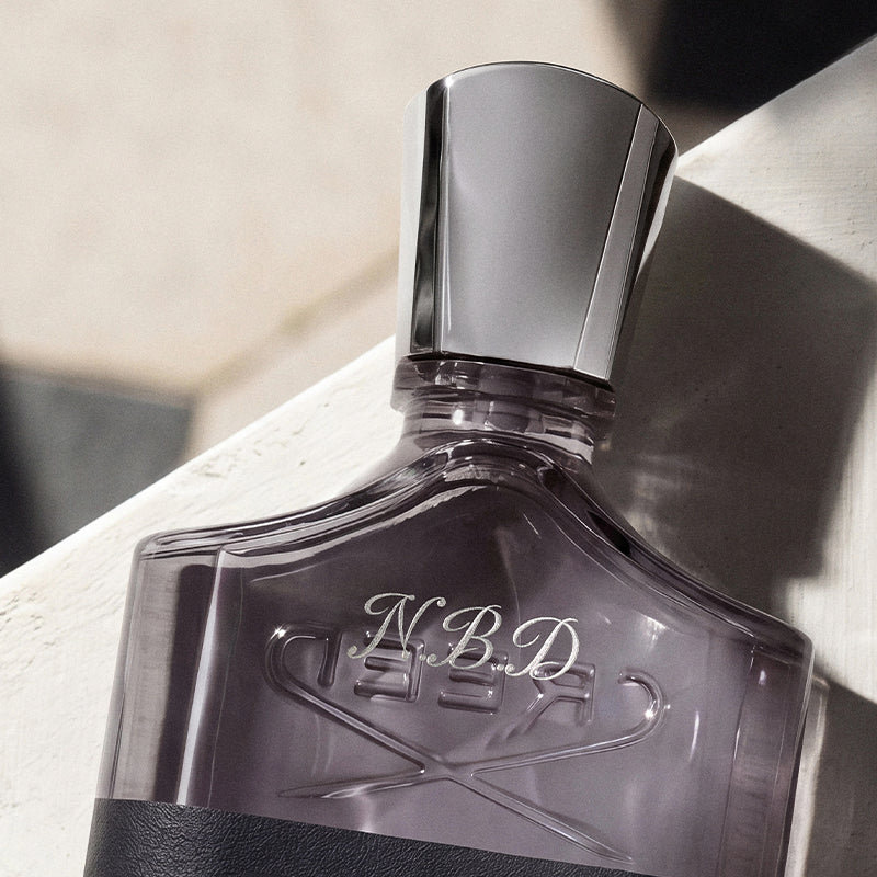 A close-up of a N.B.D. engraving on a bottle with a silver cap