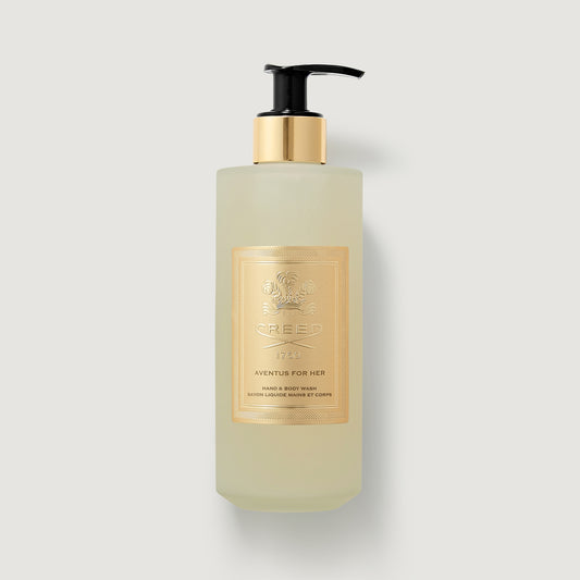 Hand soap bottle with gold pump and label on a light gray background