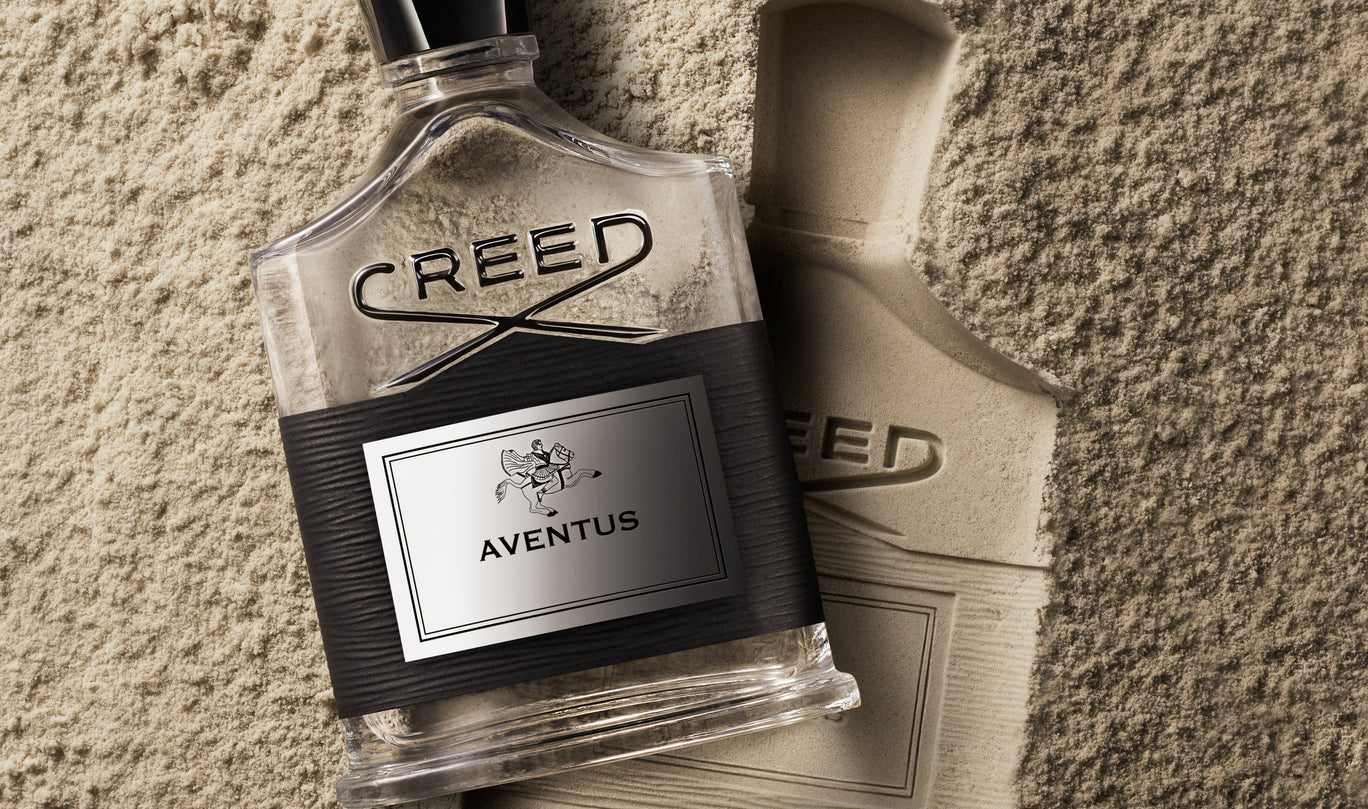 Creed Aventus perfume bottle on a textured surface