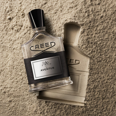 Creed Aventus perfume bottle on a textured surface