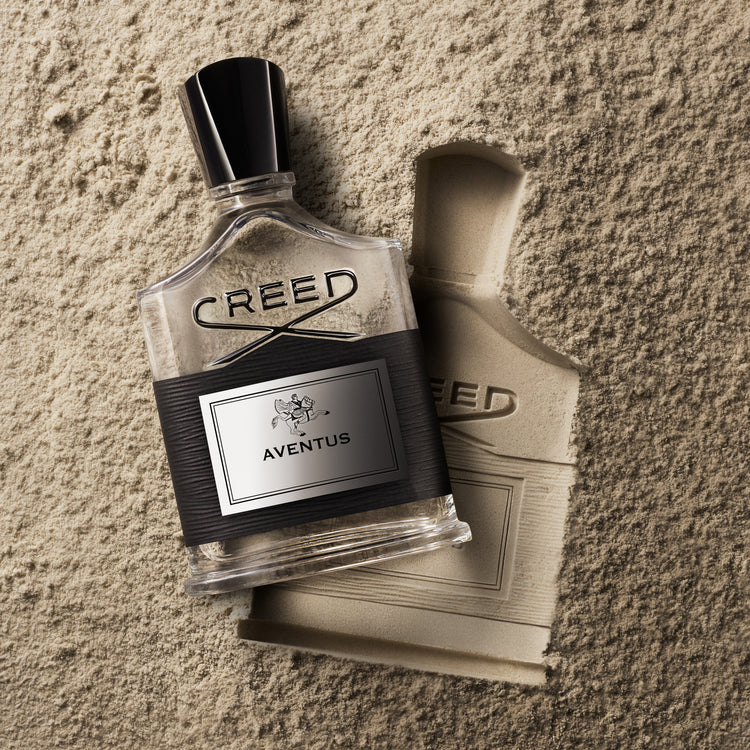 Creed Aventus perfume bottle on a textured surface