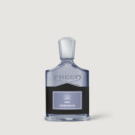 Creed Debonair Iris perfume bottle, featuring a clear glass body with a black label and a silver-toned cap, set against a solid light gray background.