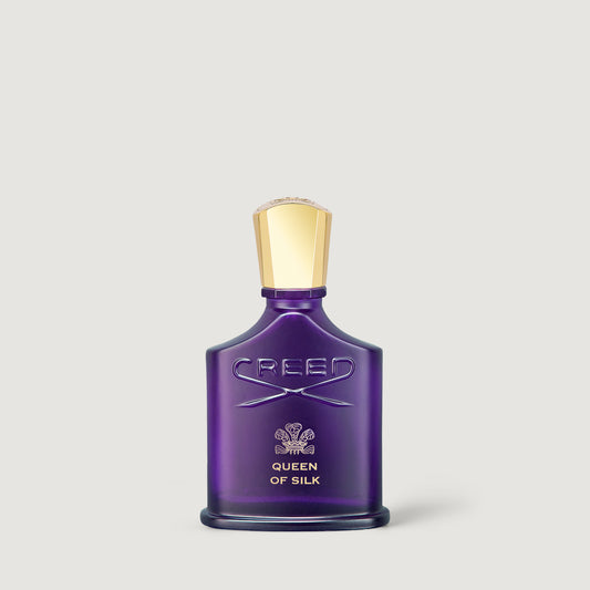 Creed Queen of Silk Eau de Parfum bottle in a deep purple glass with a metallic gold cap, centered on a light gray background.