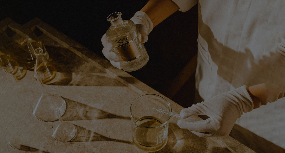 A person putting different fragrances in a glass container