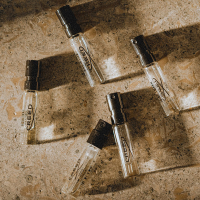 Five Creed sample perfume on a marbled surface